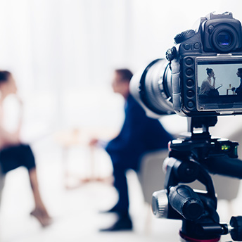 A close-up of a camera recording two people having a discussion.