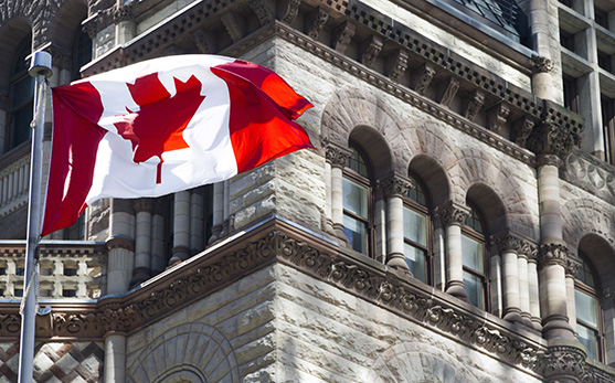 Canada flag waving outside a historical building