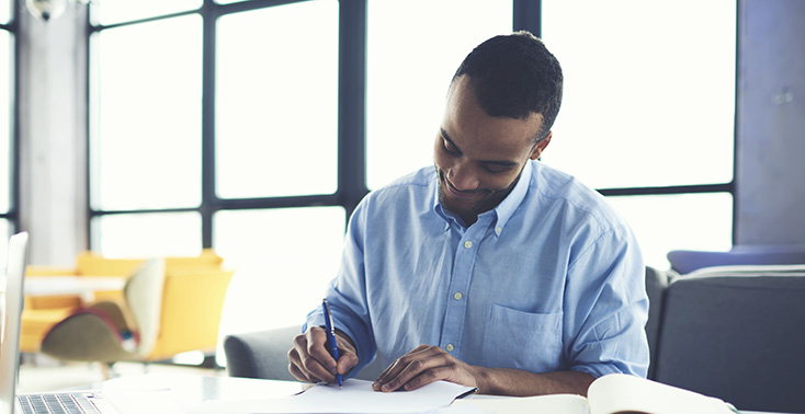 Professional writing a note in a bright office