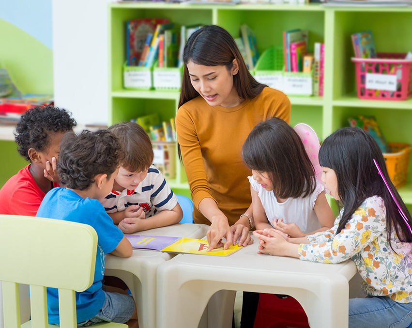A Speech-Language Pathologist works with a small group of young students