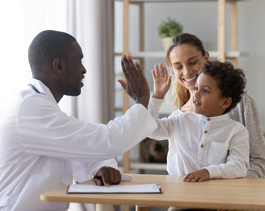 An S-LP high-fives a child sitting on their parent’s lap